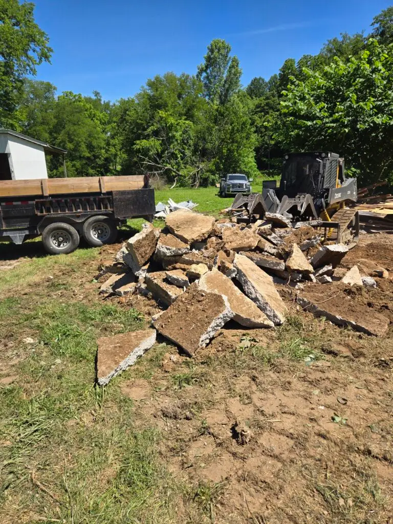 Cutting Edge Lawn and Landscapes heavy equipment breaking up old concrete in Spring Hill, TN, during a demolition project.