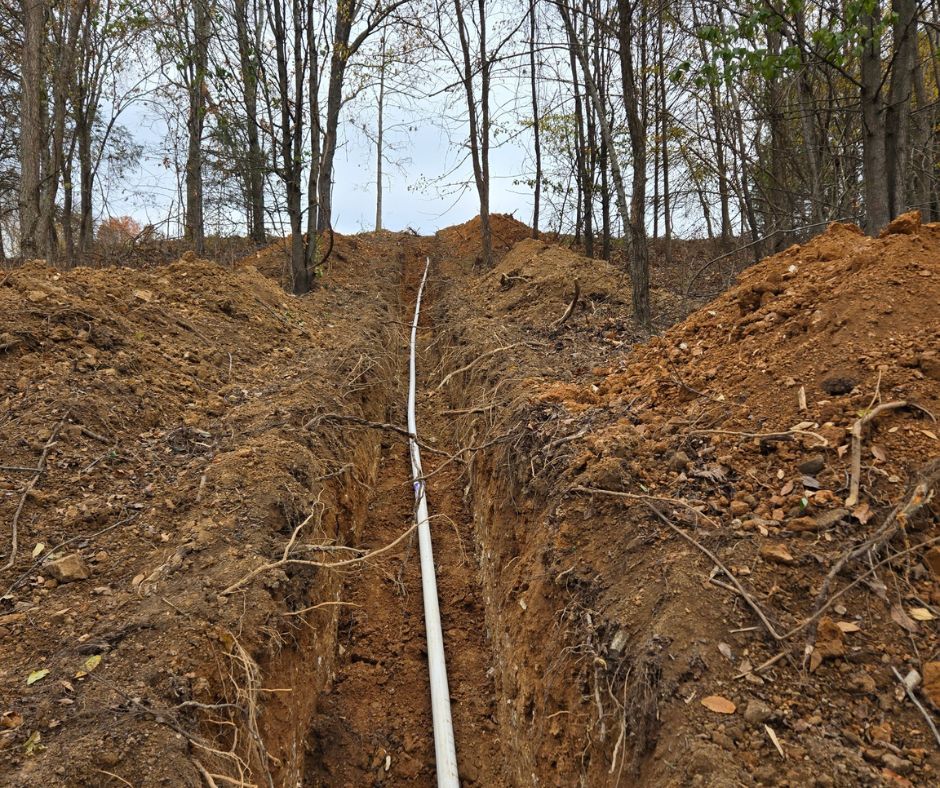 A newly installed water line running below ground level, set by the Cutting Edge crew.