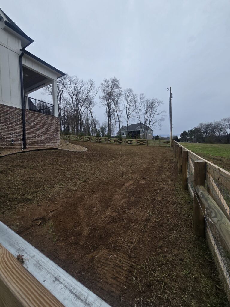 bare backyard before sod installation in Columbia TN with graded soil and fencing